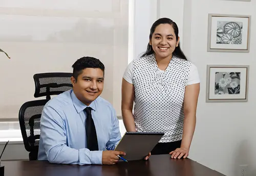 Two people in an office meeting at a desk