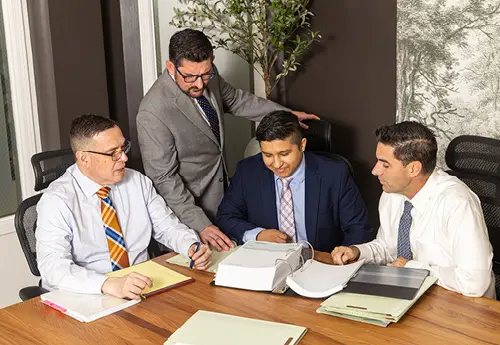 Attorneys meeting at a table reviewing documents