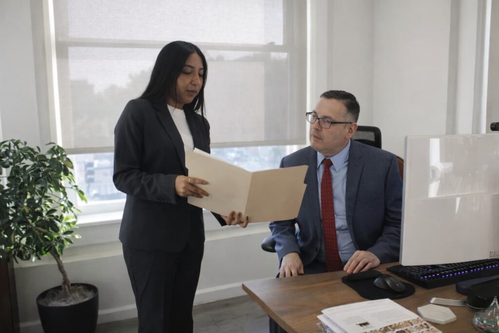 Attorney Itzel Burgos and Attorney Angel Pluas discussing a case file at Workers’ Rights Legal Group.